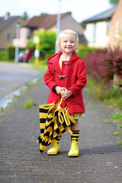 Portrait of playful little girl with colorful umbrella — ストック写真