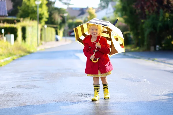 Portrait of playful little girl with colorful umbrella — Stockfoto