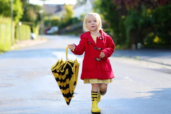 Portrait of playful little girl with colorful umbrella — ストック写真