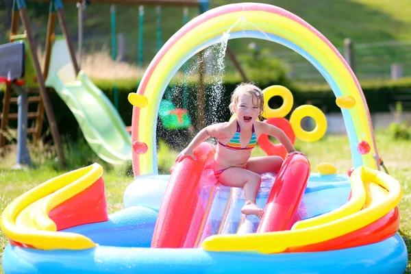 Lilla flickan har roligt i uppblåsbar pool — Stockfoto
