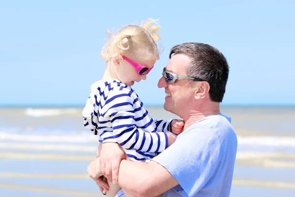 Отец и дочь обнимаются на пляже — стоковое фото