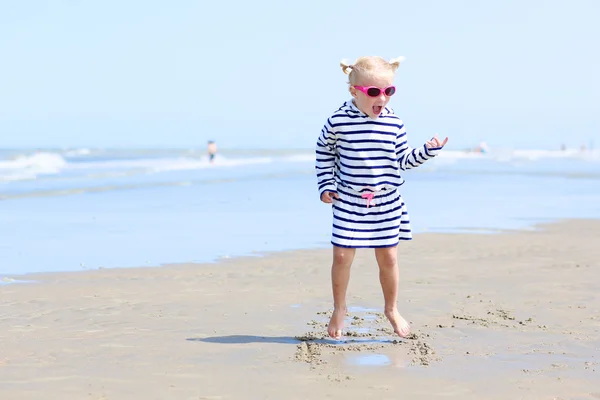 Little girl playing on the beach at summer — Stock Photo, Image