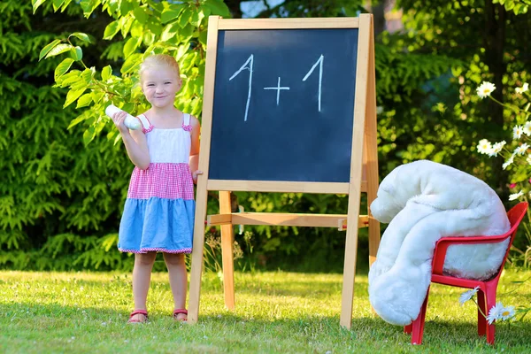 Toddler girl playing teacher with her toys — Stockfoto