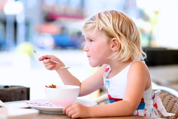 Hermosa niña comiendo helado en la cafetería — Foto de Stock