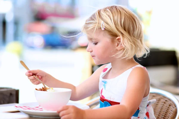 Piękna mała dziewczynka jedzenie lody w kawiarni — Zdjęcie stockowe