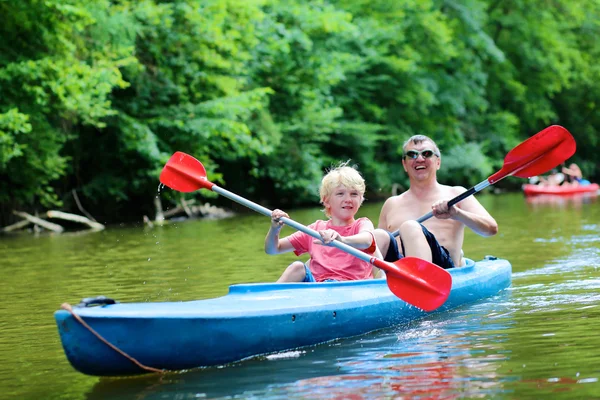 Far och son paddling på floden — Stockfoto