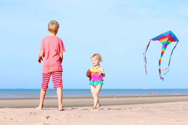 Kids playing with kite on the beach — Stockfoto