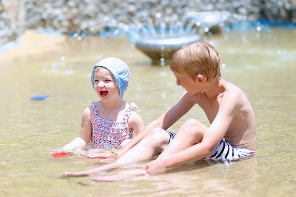 Çocuklar su ile oynayan ve yaz aylarında, kum — Stok fotoğraf