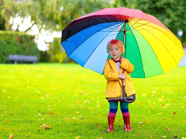 Porträt eines verspielten kleinen Mädchens mit buntem Regenschirm — Stockfoto