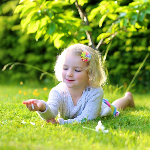 Bambino che gioca in giardino sdraiato in erba — Foto Stock