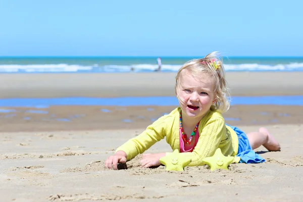 Little girl playing on the beach at summer — 图库照片