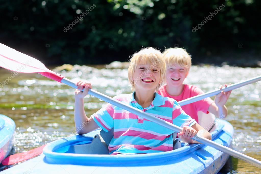 Two happy kids kayaking on the river