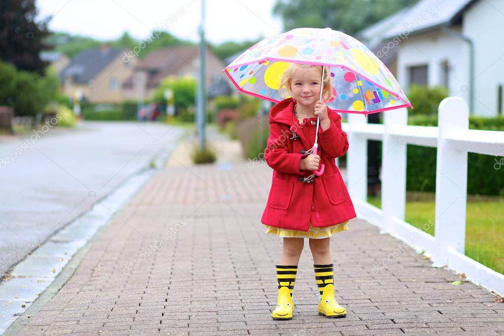 Portrait of playful little girl with colorful umbrella