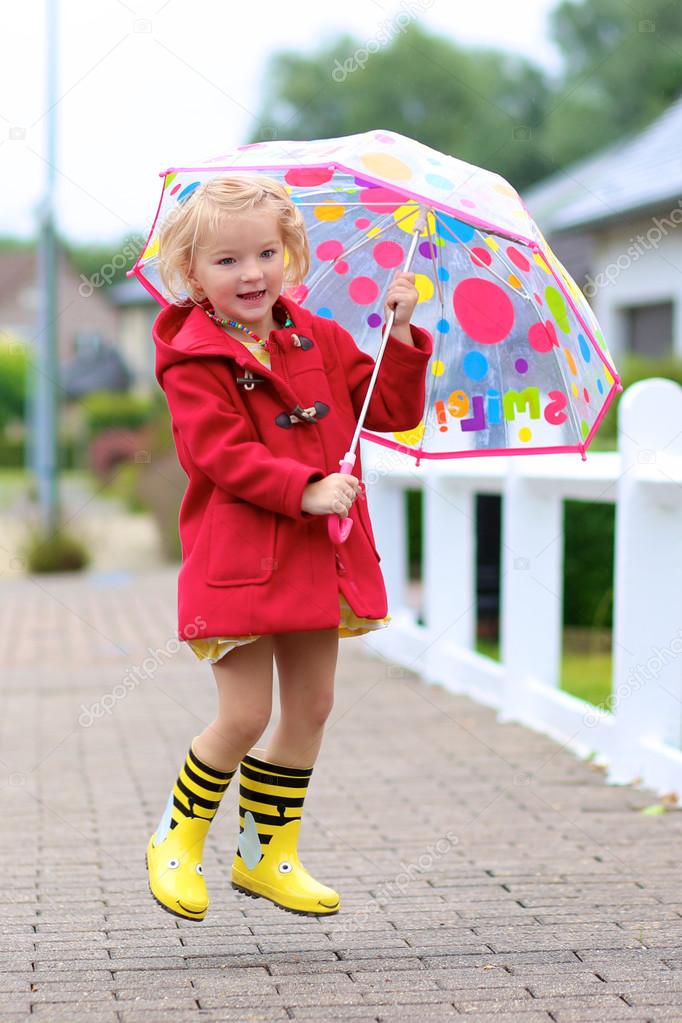 Portrait of playful little girl with colorful umbrella