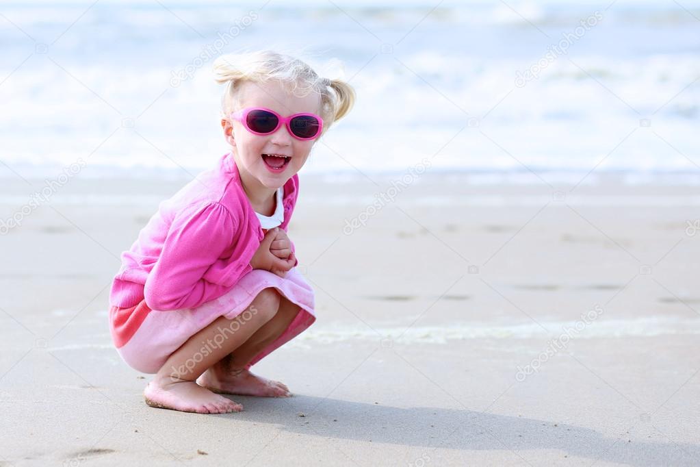 Little girl playing on the beach at summer