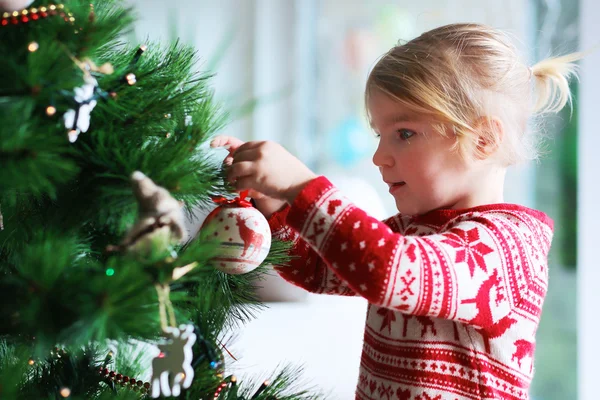 Beautiful little girl decorating christmas tree at home — Stock Photo, Image