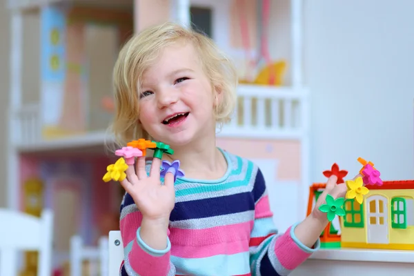 Девочка дошкольница, играющая в помещении с образовательными игрушками — стоковое фото