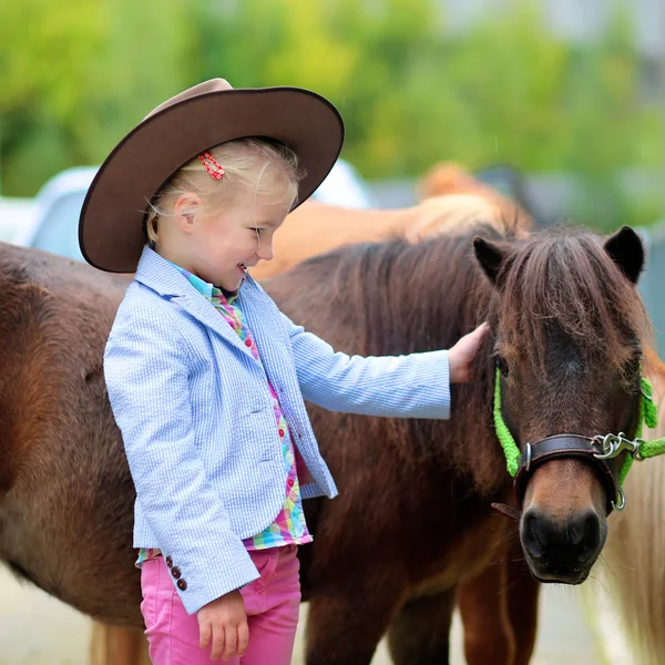 Счастливая маленькая девочка и ее пони — стоковое фото