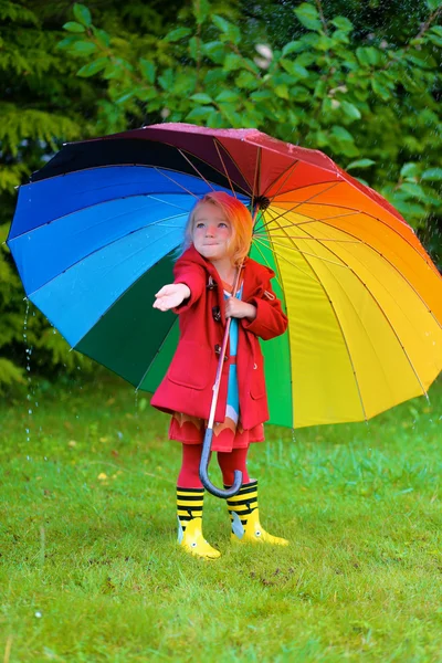 Kind mit buntem Regenschirm spielt — Stockfoto