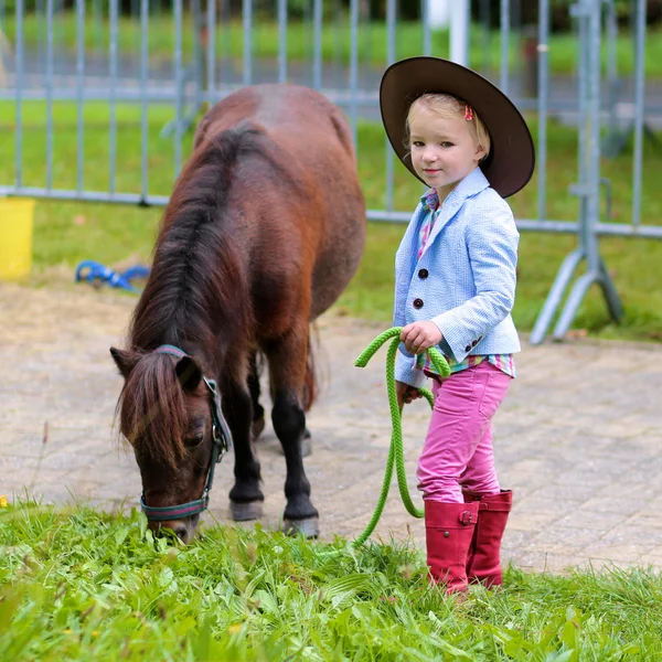 Glückliches kleines Mädchen und ihr Pony — Stockfoto