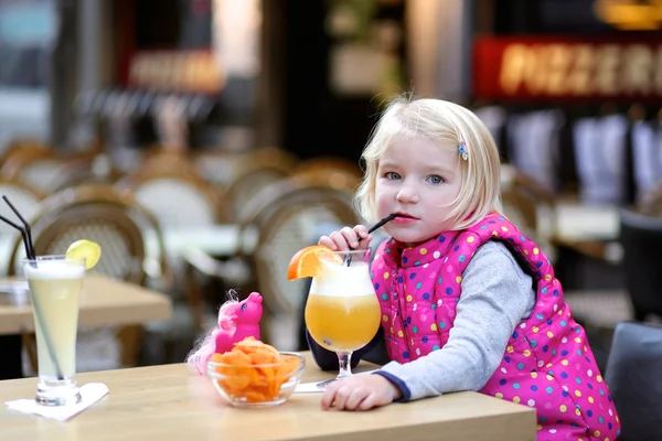 Toddler girl enjoying juice in cafe outdoors — Stock Photo, Image
