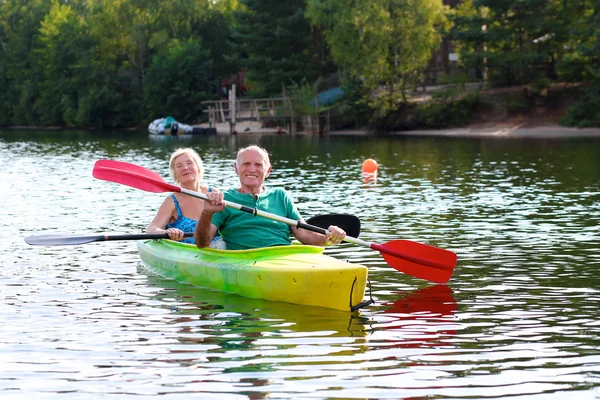 Gesunde Senioren paddeln auf dem Fluss — Stockfoto