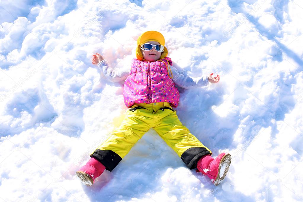 Little girl enjoying winter vacation at Alpine ski resort