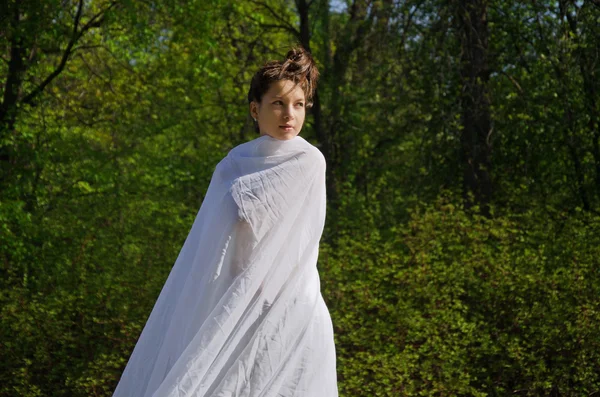 Jeune belle femme marche à travers le parc — Photo