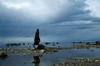 Kız bir kayalık kıyısında