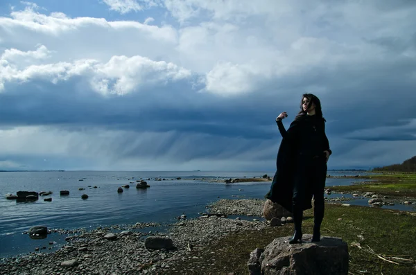 Flicka på en stenig strand — Stockfoto