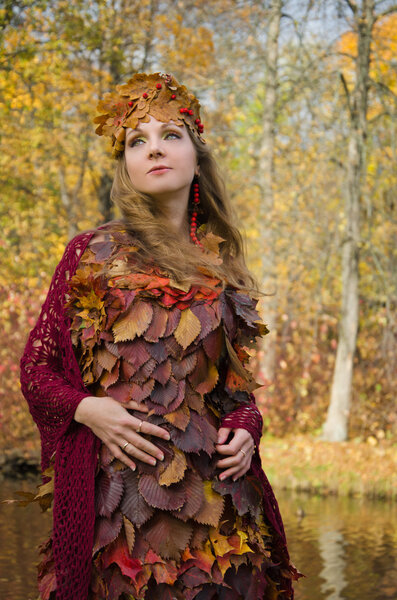 Autumn image. The girl in The fantasy style. Dress of fallen leaves.