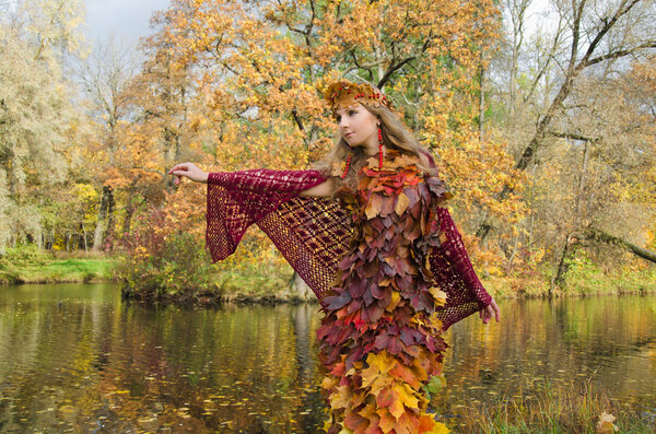 Autumn image. The girl in The fantasy style. Dress of fallen leaves.