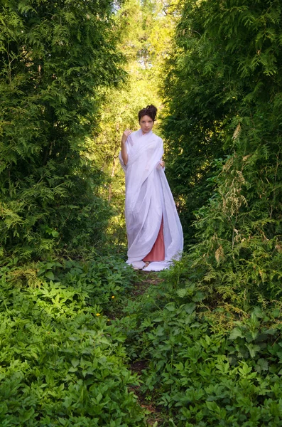 Hermosa mujer oriental camina en jardín — Foto de Stock