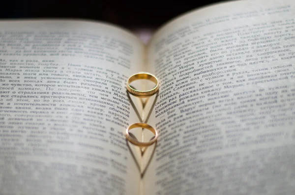 Anéis de casamento de ouro em um livro — Fotografia de Stock