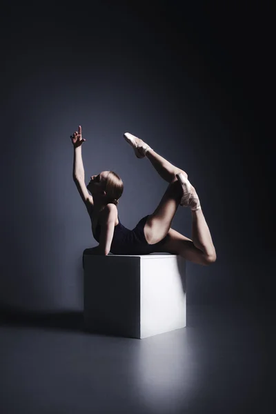 Jeune ballerine en tissu sombre danse dans l'obscurité du photostudio — Photo