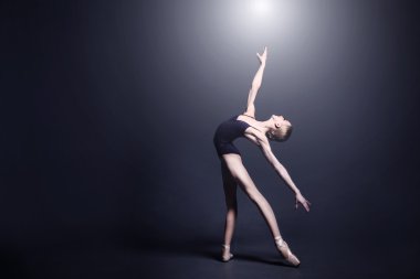 Karanlık bez içinde genç balerin photostudio karanlık bir dans ediyor