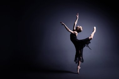 Karanlık bez içinde genç balerin photostudio karanlık bir dans ediyor