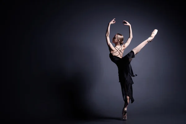 Jeune ballerine en tissu sombre danse dans l'obscurité du photostudio — Photo