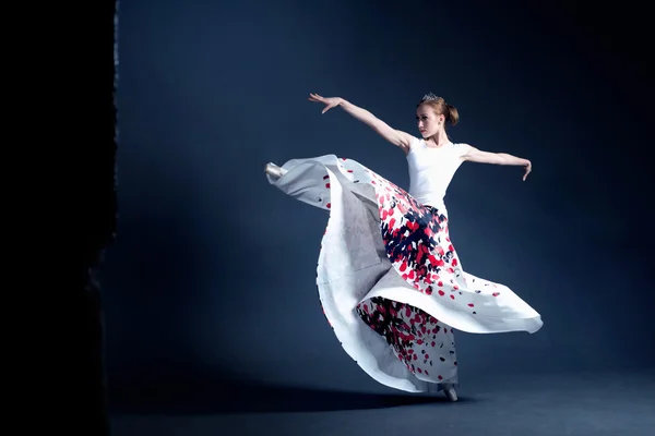 Joven bailarina con un cuerpo perfecto está bailando en el fotoestudio en diferentes vestidos —  Fotos de Stock