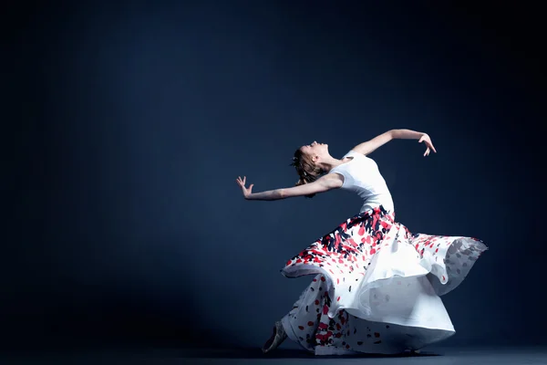 Joven bailarina con un cuerpo perfecto está bailando en el fotoestudio en diferentes vestidos —  Fotos de Stock