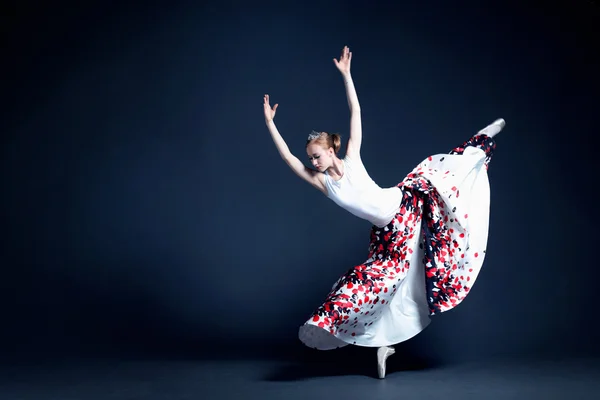 Joven bailarina con un cuerpo perfecto está bailando en el fotoestudio en diferentes vestidos —  Fotos de Stock