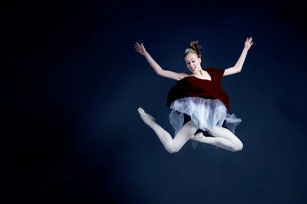 Young ballerina with a perfect body is dancing in the photostudio in different dresses — Stock Photo, Image