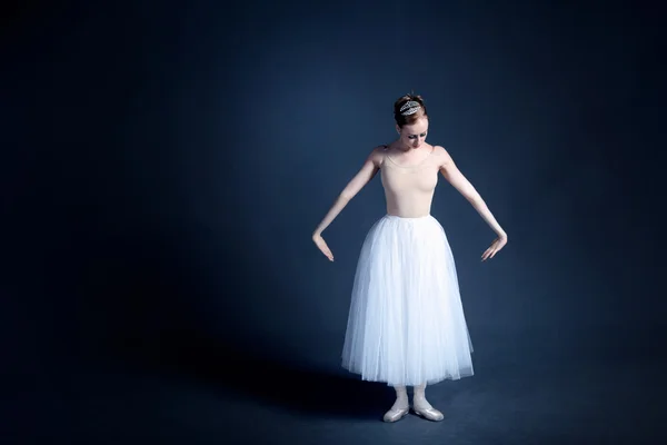 Young ballerina with a perfect body is dancing in the photostudio in different dresses — Stock fotografie