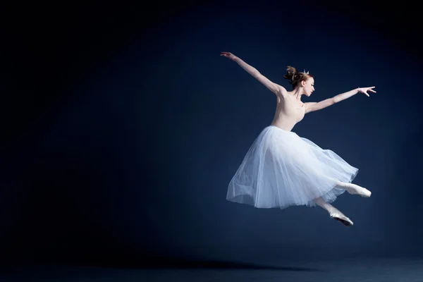 Young ballerina with a perfect body is dancing in the photostudio in different dresses — Stock fotografie