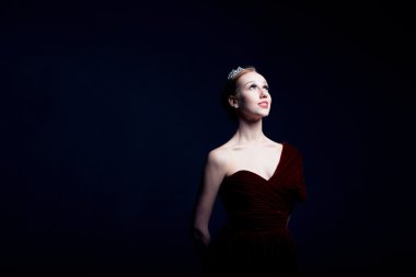 Young ballerina with a perfect body is dancing in the photostudio in different dresses