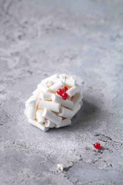 Çağdaş Kırmızı Meyve ve Kiraz Çayı Bireysel Kremalı Kek, gri arkaplanda Meringue Kurabiyeleriyle süslenmiştir..