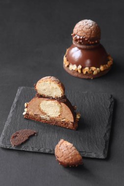 Çağdaş Çikolatalı Mousse Pastası ile Craquelin Choux Pastası, çikolata aynası jöleli, koyu bir arka planda..