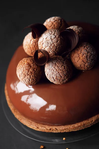 Çağdaş Çikolatalı Mousse Pastası ile Craquelin Choux Pastası, çikolata aynası jöleli, koyu bir arka planda..
