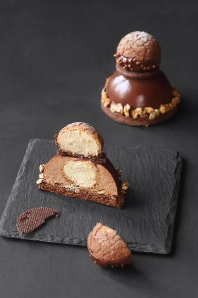 Çağdaş Çikolatalı Mousse Pastası ile Craquelin Choux Pastası, çikolata aynası jöleli, koyu bir arka planda..