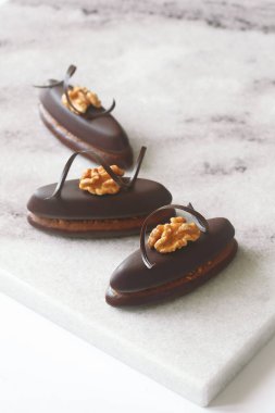 Ceviz ve çikolata sarmalı, açık mermer tahtada, beyaz arka planda, Praline 'li çikolatalı kurabiye..
